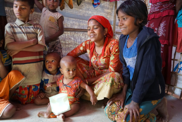 Children in Bangladesh gather around their solar light