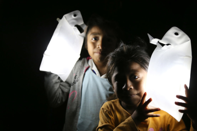 Children in Peru carry their solar lights in the dark