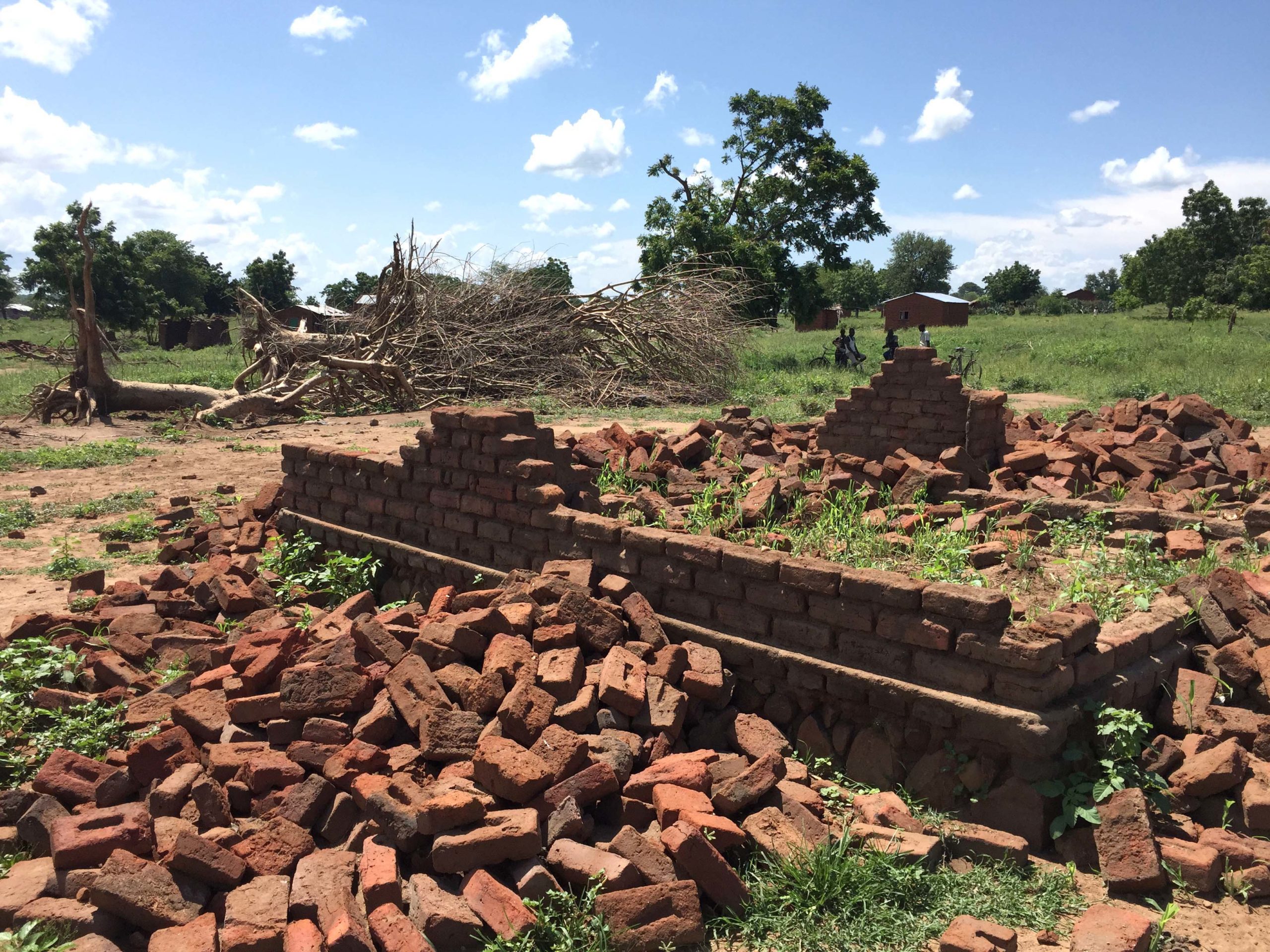 A pile of bricks surrounds the frame of a destroyed house in Malawi