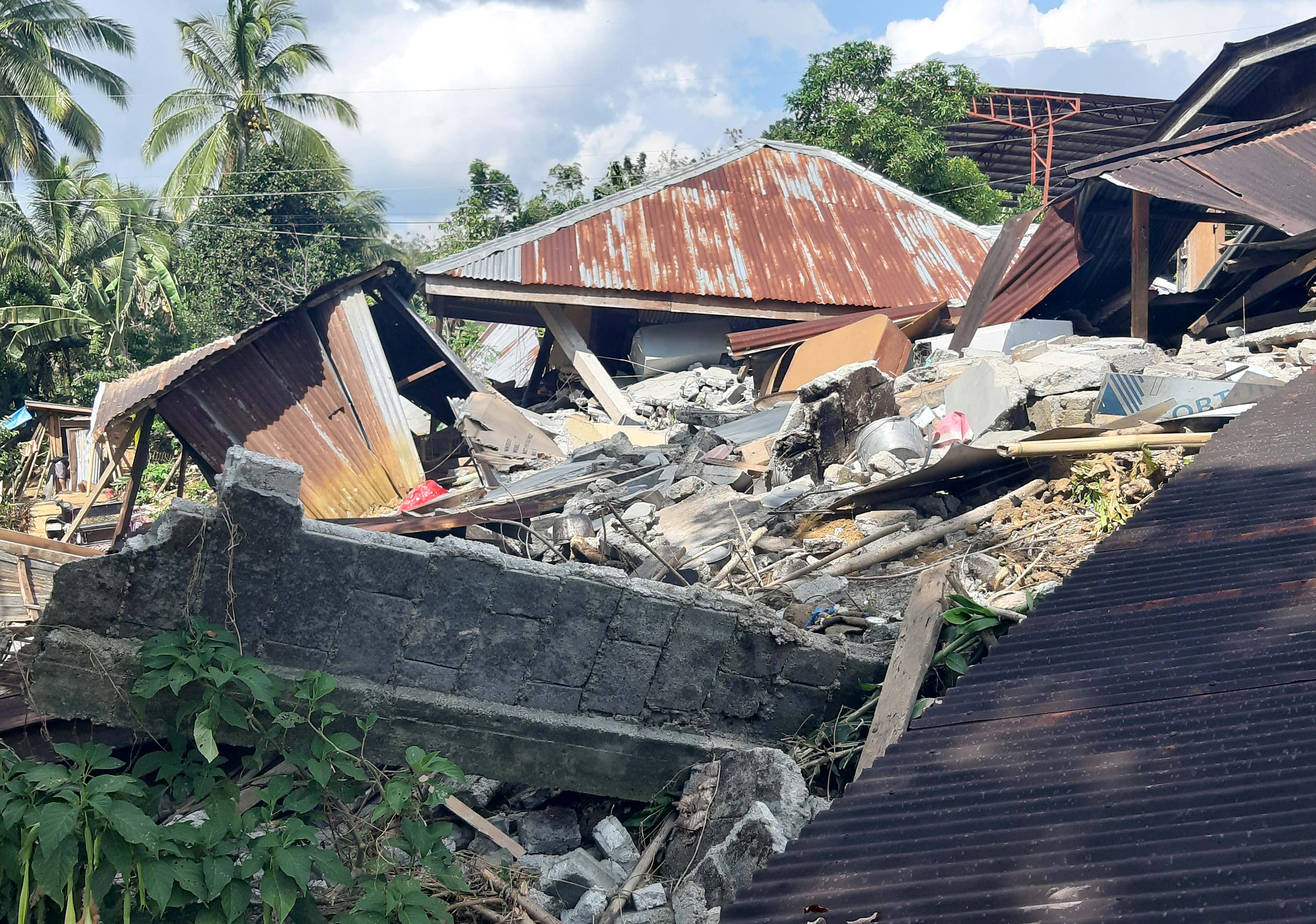 A destroyed house with rubble around it