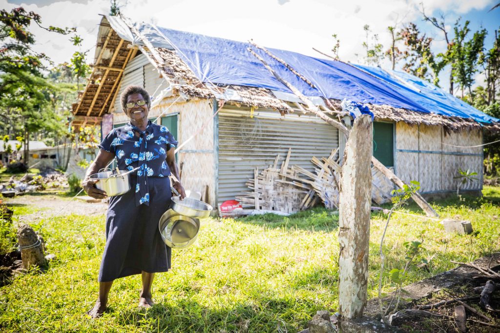 Risa Williams (63) at her home in Pangi, South Pentecost. Risa shows off the kitchen kit she recieved. Risa says she is very happy with the quality of the items and feels so blessed that people have thought of her and her family.