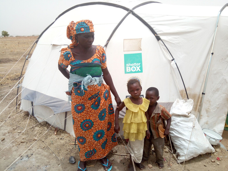 woman and children outside tent