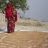 Behula stands on a tarp full of drying rice