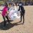 Three people hold a bag of aid that says ShelterBox and Rotary