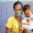 A woman holds her child, who is carrying a shelterbox solar light