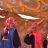 Two women from Sudan standing under a tent made of beautiful fabric