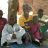 A woman sits with four children surrounding her