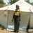 A woman stands in front of a tent.