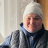 A woman wearing winter clothing stands in her home holding a solar light