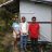 Filippino family stand proudly outside their emergency shelter after Typhoon Rai