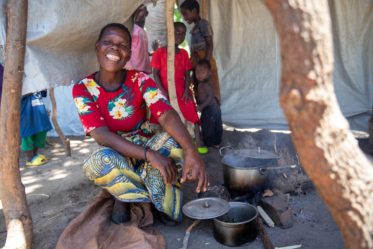 Woman sits with her ShelterBox aid in her shelter